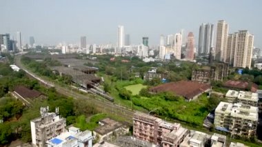 MUMBAI / INDIA - 27 Ekim 2020: Mumbai Parel 'de bir Mumbai yerel treni geçerken, konut ve ticari binaların genel görünümü.