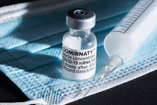 네덜란드의 덴 헬 더입니다. 2021 년 5 월. An ampoule of comirnaty vaccine, a mouth mask and a injection needle. — 스톡 사진