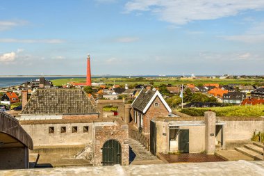 Den Helder, Hollanda - 2 Ağustos 2019. Deniz feneri 'Lange Jaap', Hollanda 'dan Den Helder ile Huisduinen kıyı köyünün Napolyonist Fort Kijkduin manzarası.