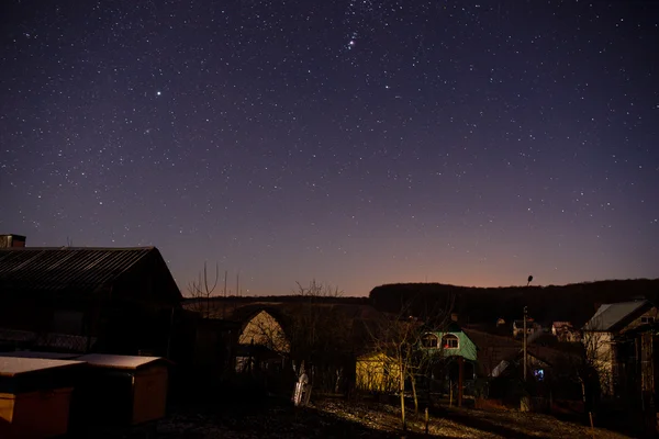 Casa de madera sobre un fondo del cielo nocturno — Foto de Stock