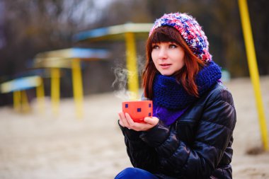 жінка п'є каву на березі моря