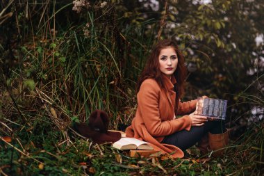 Bir kitap sokak tutarak şapkalı kız