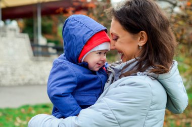 Holding bebek açık havada sonbaharda anne