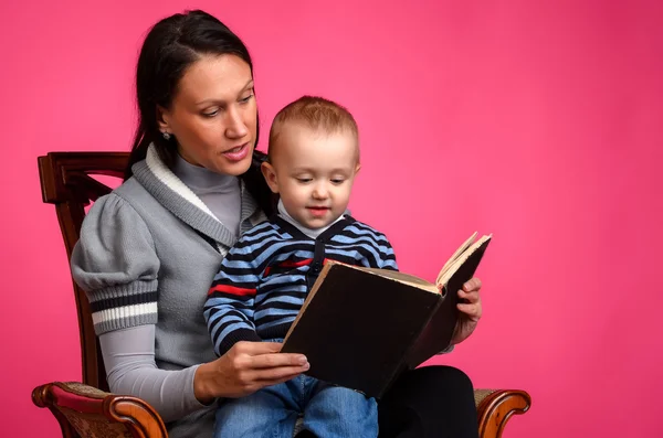 Mom son reading a book, sitting in a vintage chair