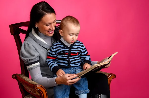 Mom son reading a book, sitting in a vintage chair