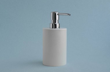 Mavi arka plandaki beyaz sabun makinesi. Hijyen ve sağlık kavramı.