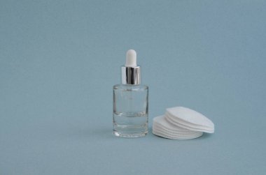 Mavi arka planda pipetli ve pamuklu bir şişe.