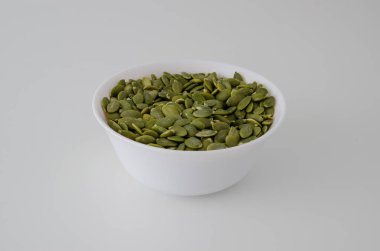 Temiz bir arkaplanda kabak çekirdeği olan beyaz tabak. Uygun beslenme.