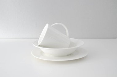 Beyaz arka planda beyaz temiz tabaklar. Minimalist tablo takımı