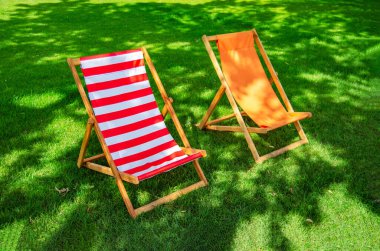 Yeşil çimenlikteki parlak sandalyeler. Yaz tatili
