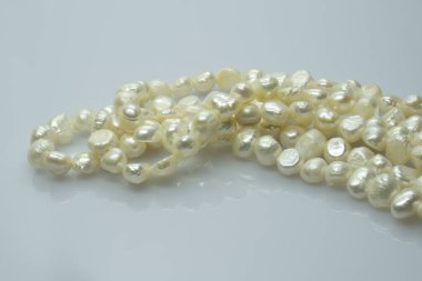 Hafif arkaplanda yansıması olan inci kolye.