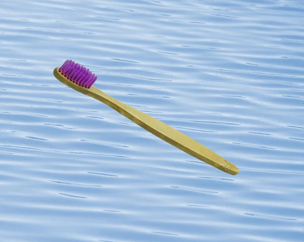 wooden toothbrush with water and waves background