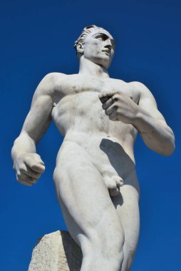 Roma 'daki Stadio dei Marmi' nin çıplak kaslı erkek heykeli ve gökyüzü arkaplanı