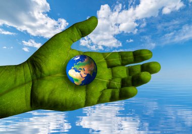 Environment Earth Day. The world turns to climate action. A hand with the texture of a green leaf supports the world