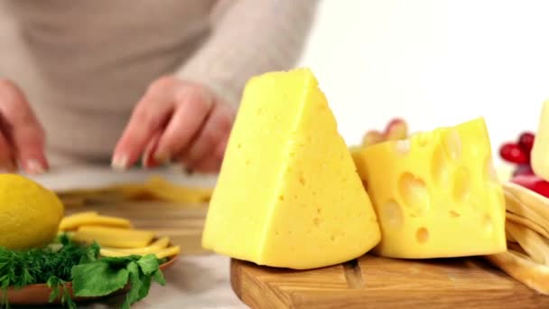 A woman prepares a snack of cheese with white wine. — Stock Video