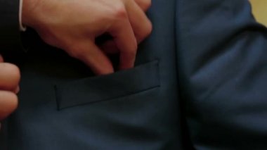 Bir yaka çiçeği cebine koyarak