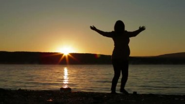 Şafakta hamile kadın egzersiz yaparak.