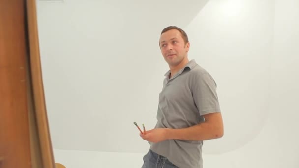 Manlig konstnär arbetar med målning i studio — Stockvideo