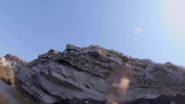 Tiener meisje springt van een klif in het water stijgt een heleboel bubbels, fotograferen onder water.girl tiener springen van een rots in het water — Stockvideo