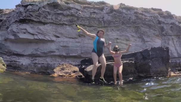 Mãe e filha saltando de um penhasco para a água. Vídeo filmado no Gopro — Vídeo de Stock