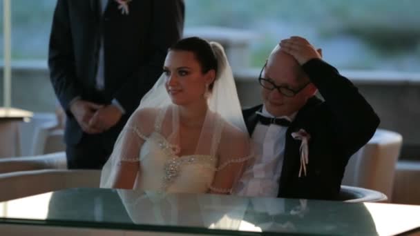 Brudgummen och bruden sitter vid bord — Stockvideo