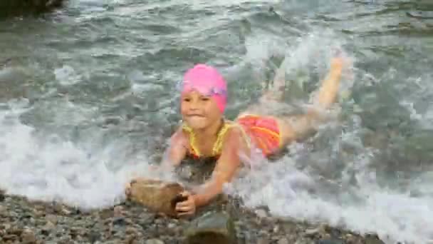 Маленькая девочка плавает в море — стоковое видео
