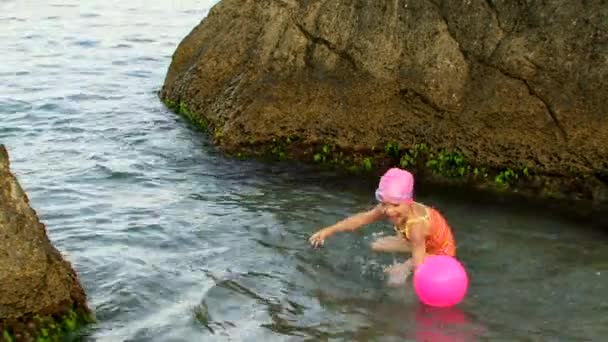 Mädchen mit Mutter spielt Ball im Meer — Stockvideo