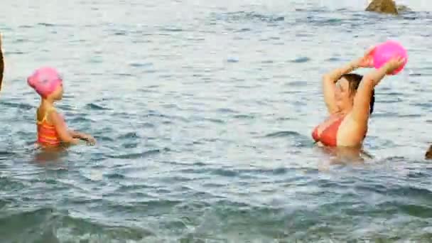 Chica jugando pelota en el agua de mar — Vídeos de Stock