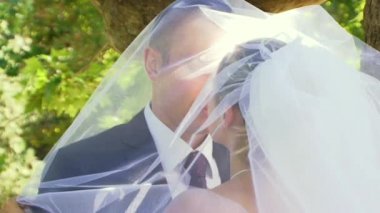 Romantik gelin peçe altında öpüşme.