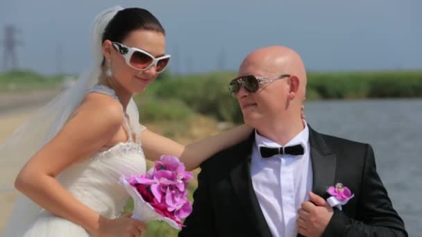 Novia y novio en gafas de sol posando en la naturaleza — Vídeos de Stock