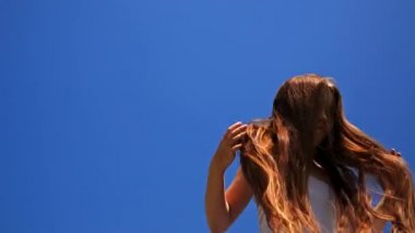 Mutlu kız mavi gökyüzü arka plan üzerinde atlama