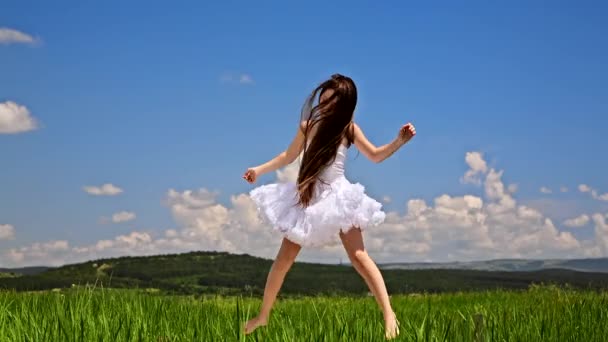 Roztomilá dívka, která skočila na zelené louce — Stock video