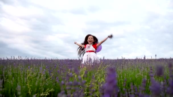 Fröhliches Mädchen springt in Lavendel — Stockvideo