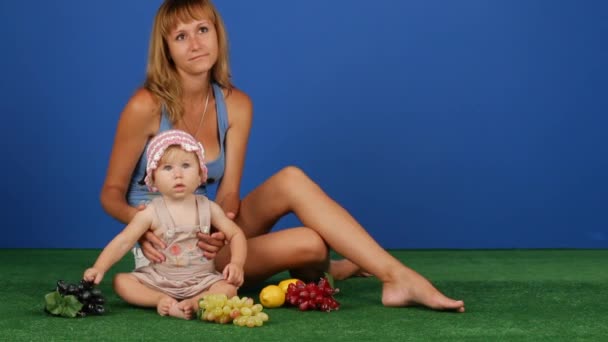 Mamá y su hija en la hierba verde — Vídeo de stock