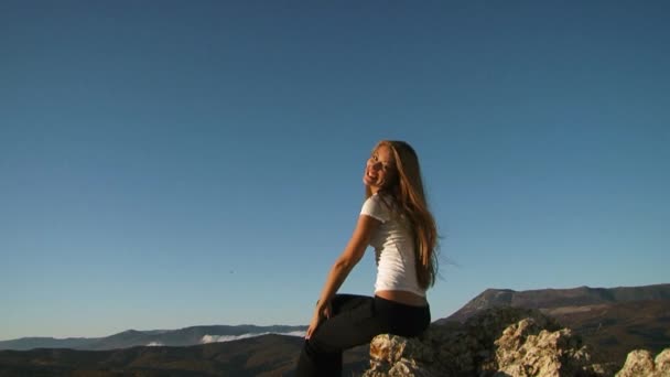 Verspieltes Mädchen sitzt auf dem Felsen — Stockvideo