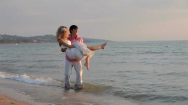 Adam kız arkadaşı kollarında tutar.