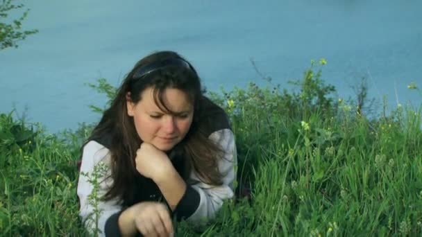 Женщина лежит рядом с озером — стоковое видео