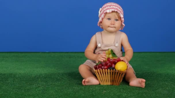 Meisje houdt van druiven op een blauwe achtergrond — Stockvideo