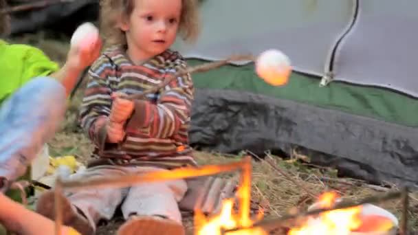 Το αγόρι και το κορίτσι τηγανίζουμε ένα Ζέφυρος σε μια πυρκαγιά. — Αρχείο Βίντεο