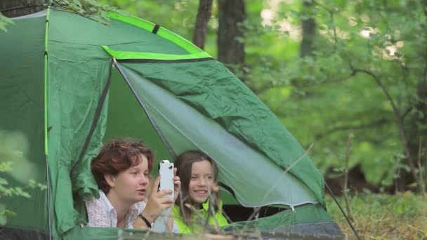 Meisjes en de kleine jongen, bewonderen de aard liggen in tent. — Stockvideo