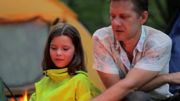 Sent på kvällen i lägret, far och dotter sitta vid elden — Stockvideo