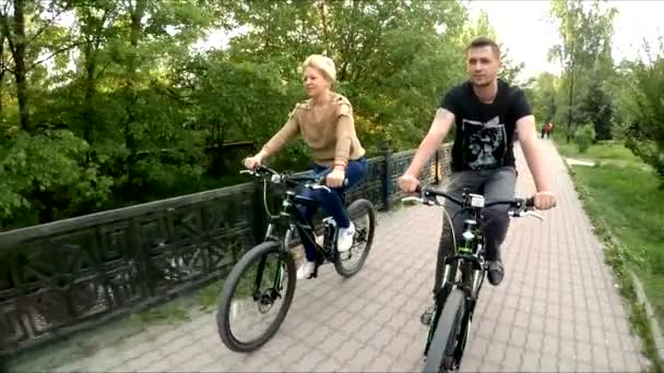 Mladá rodina tří jízdních kol jízda podél cesty na řece — Stock video