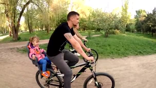 Счастливая семья езда на велосипедах в парке — стоковое видео