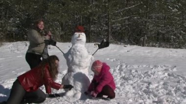 Anne kızı ve kardan adam ve bir gülümseme ile birlikte ele geçirilmesi
