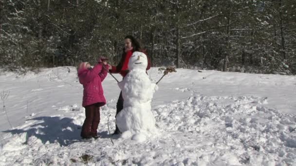 Familia edificio muñeco de nieve en el jardín — Vídeo de stock