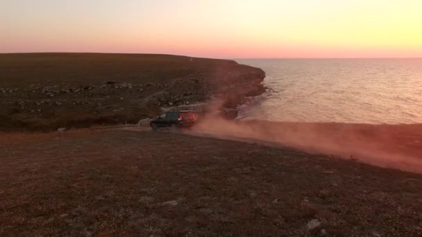 Luftaufnahme. Offroader-Auto, das bei Sonnenuntergang entlang der Küste von Tarkhankut fährt, Krim — Stockvideo