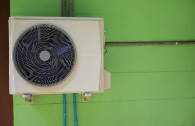 Beton duvara monte edilmiş soğutucu klima yeşile boyanmış..