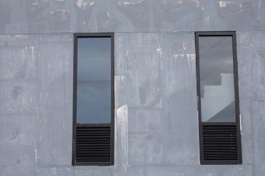 Gri bina duvarındaki cam pencere