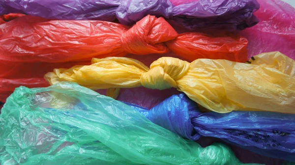 Plastic bags of different rainbow colors tied in a knot. International plastic bag free day. Say no to plastic. Go green. Save nature. Save ocean. World ocean day. Company against plastic bags.