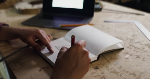 Hombre hace un dibujo a lápiz en un cuaderno usando una regla de primer plano — Vídeos de Stock